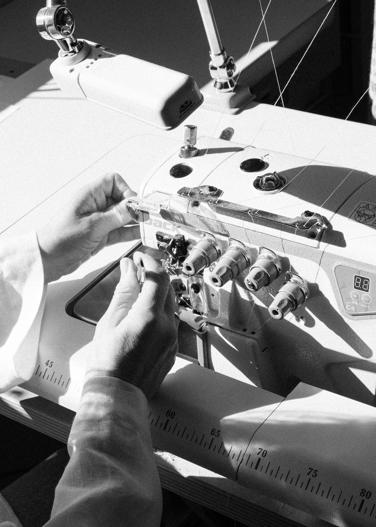 A seamstress working at a sewing machine in the LAUNIL studio.