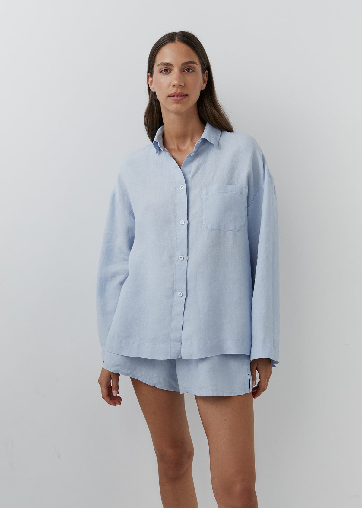 Blue long-sleeved linen shirt with a single chest pocket.