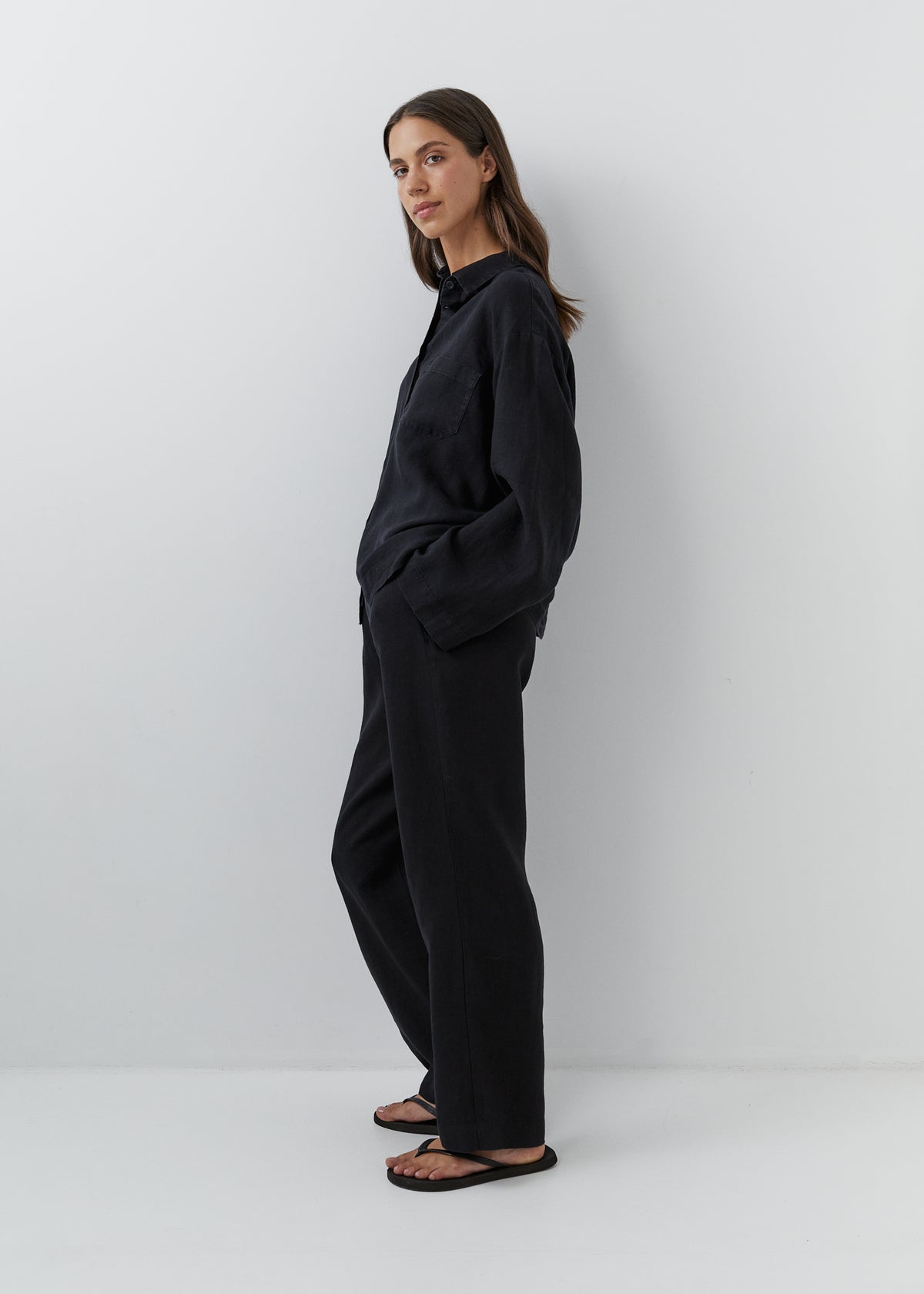 Women’s black linen pajamas with a long-sleeved shirt and high-waisted trousers.