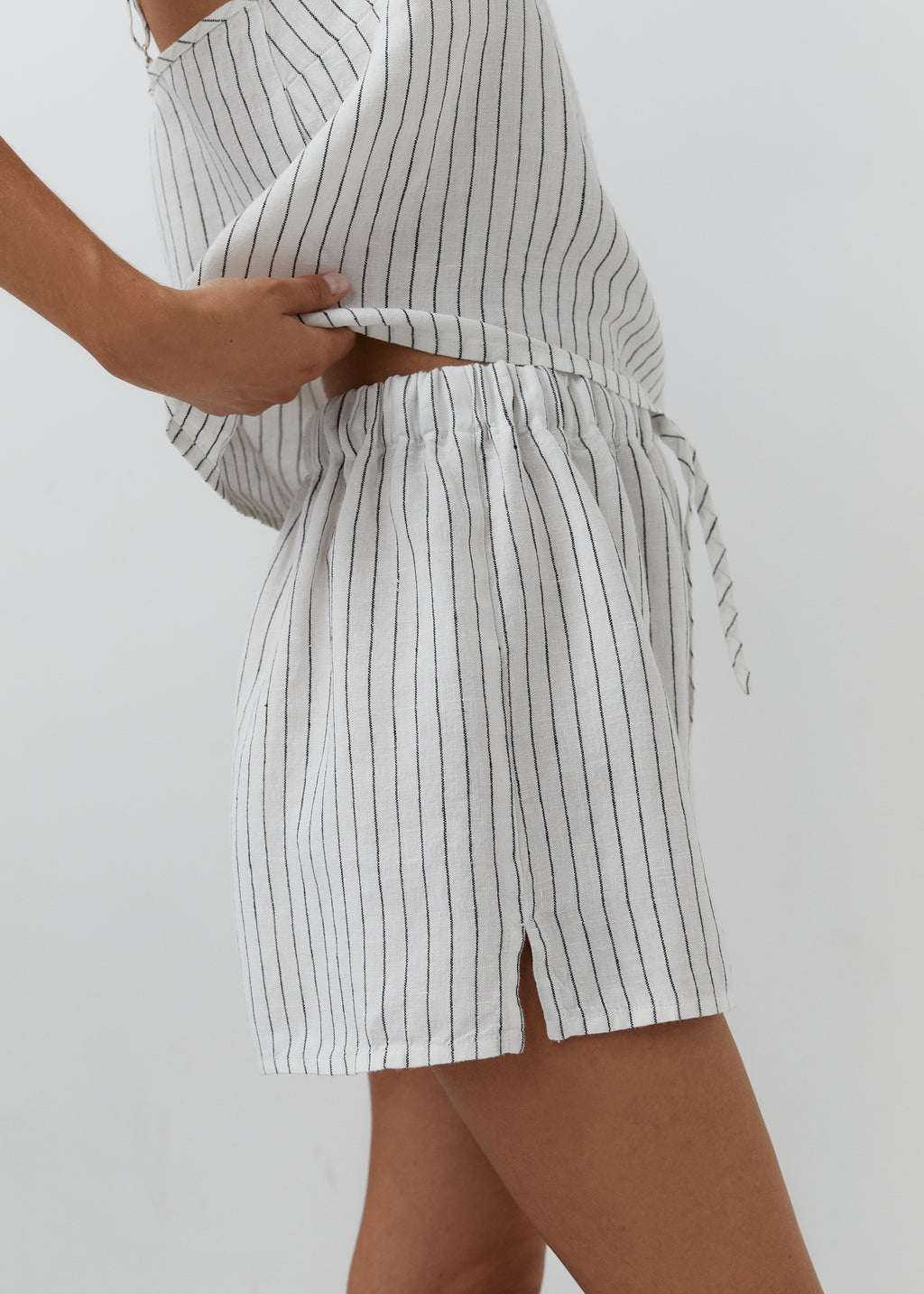 White and black striped linen shorts with an elasticated drawstring waistband.