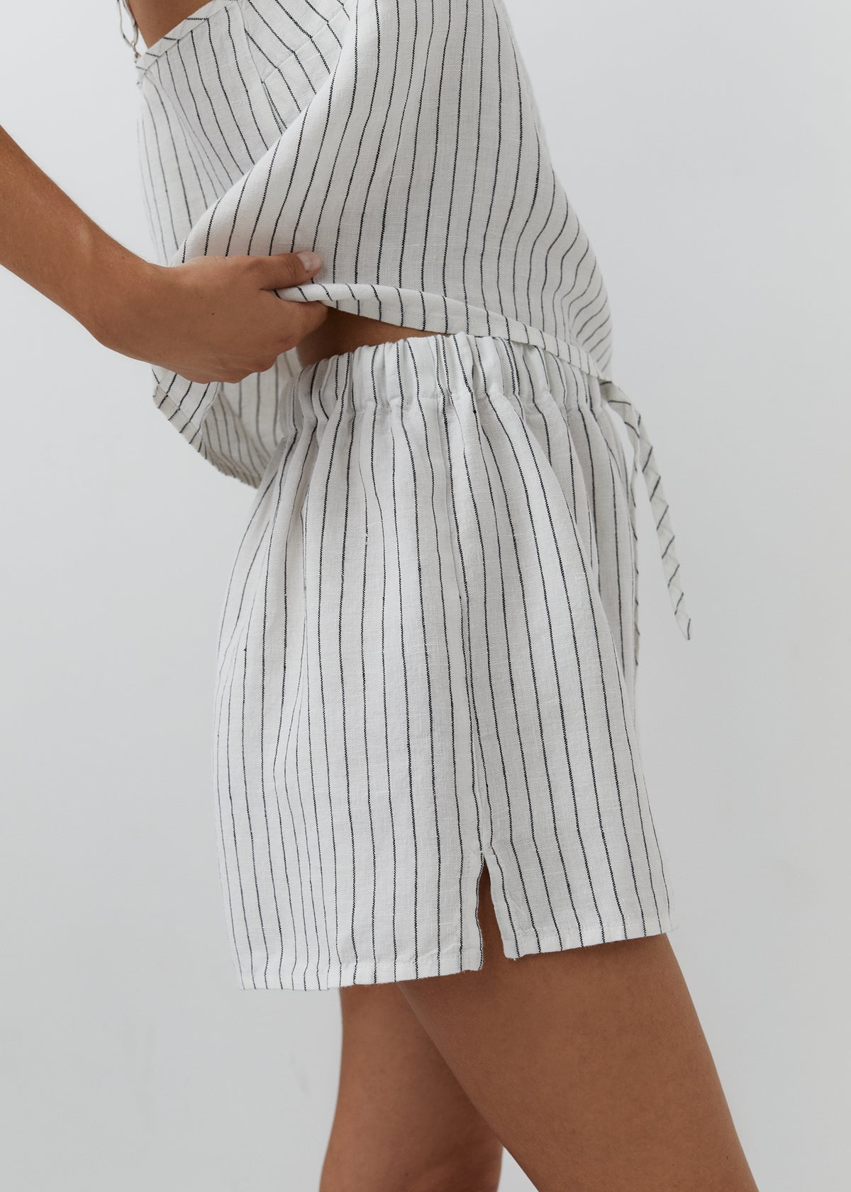 White and black striped linen shorts with an elasticated drawstring waistband.