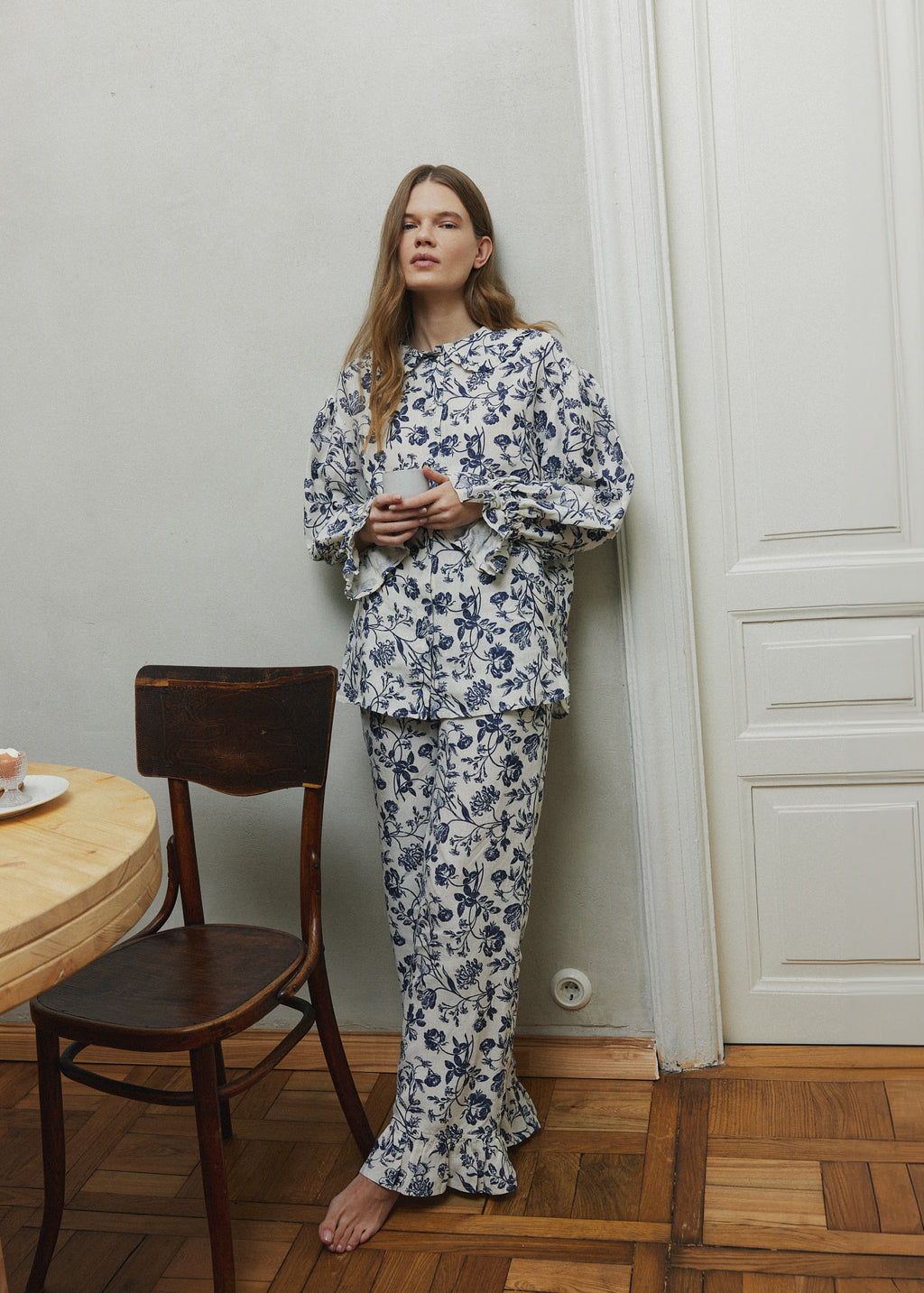 Blue and white floral linen pyjama set, a long-sleeve button-up shirt and flared pants that fall softly to the floor.