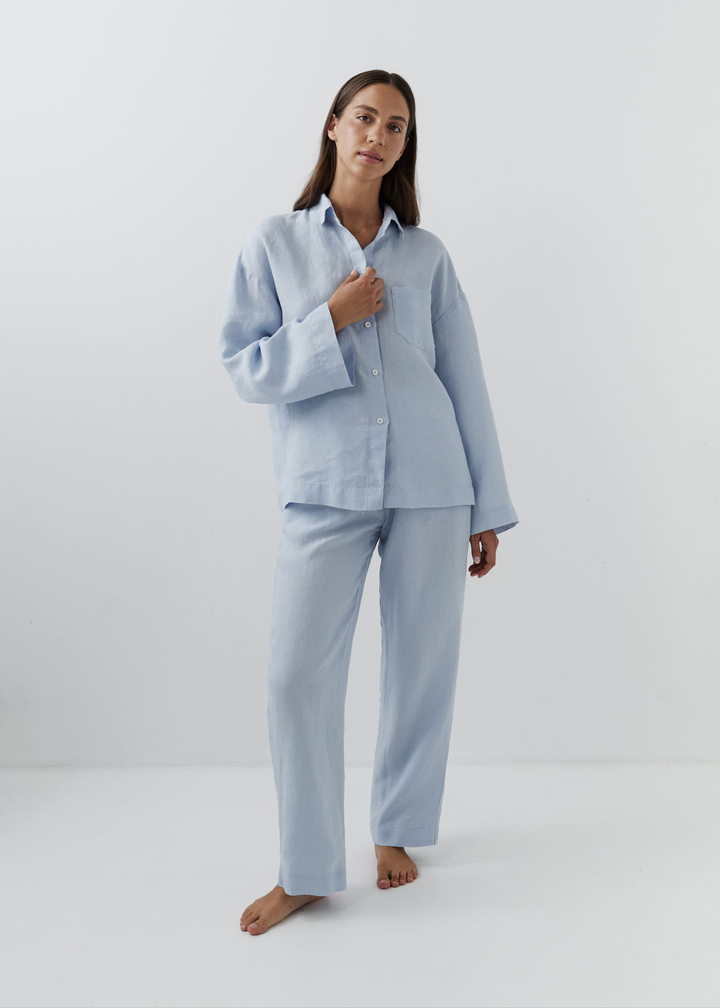 Woman wearing blue linen pants with a matching button-down shirt.