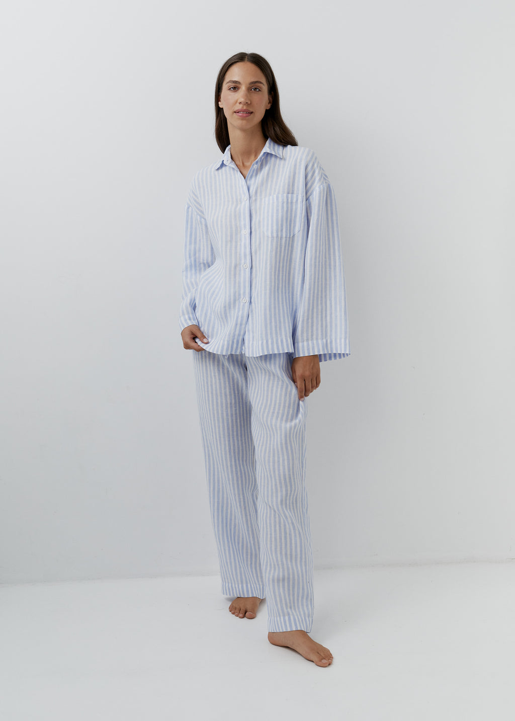 Woman wearing blue and white striped linen pants with a matching shirt.
