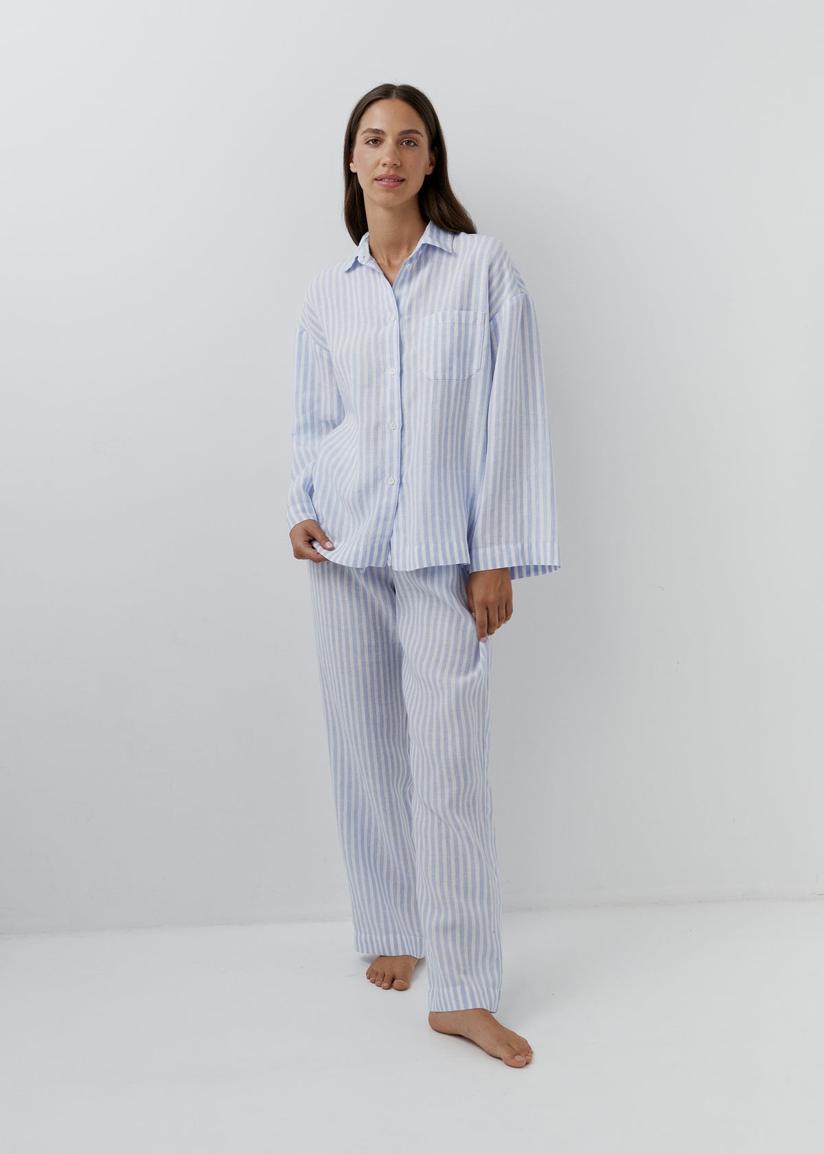 Woman wearing blue and white striped linen pants with a matching shirt.
